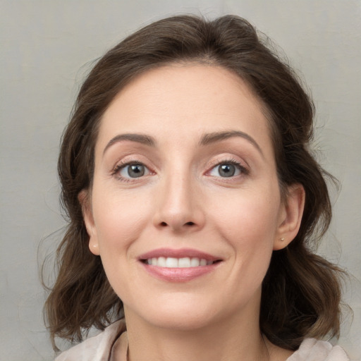 Joyful white young-adult female with medium  brown hair and grey eyes