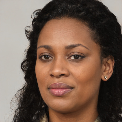 Joyful black young-adult female with long  black hair and brown eyes