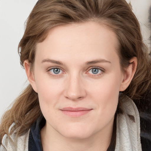 Joyful white young-adult female with long  brown hair and blue eyes