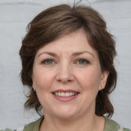 Joyful white adult female with medium  brown hair and grey eyes