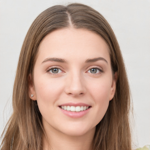 Joyful white young-adult female with long  brown hair and green eyes