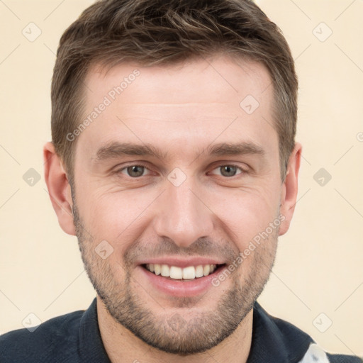 Joyful white young-adult male with short  brown hair and grey eyes