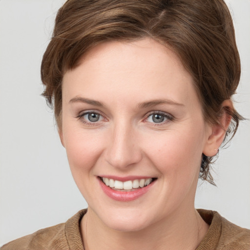 Joyful white young-adult female with medium  brown hair and blue eyes