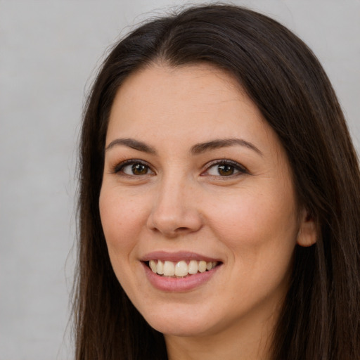 Joyful white young-adult female with long  brown hair and brown eyes