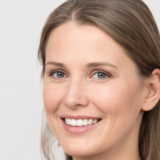 Joyful white young-adult female with long  brown hair and brown eyes