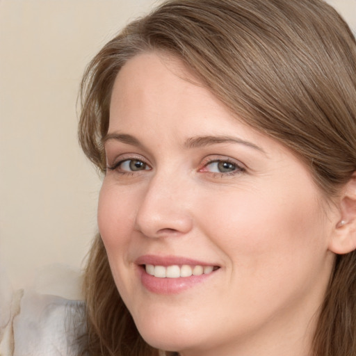 Joyful white young-adult female with long  brown hair and blue eyes