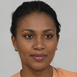 Joyful black young-adult female with short  brown hair and brown eyes
