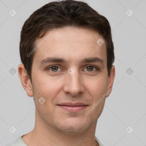 Joyful white young-adult male with short  brown hair and grey eyes