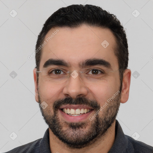 Joyful white young-adult male with short  black hair and brown eyes