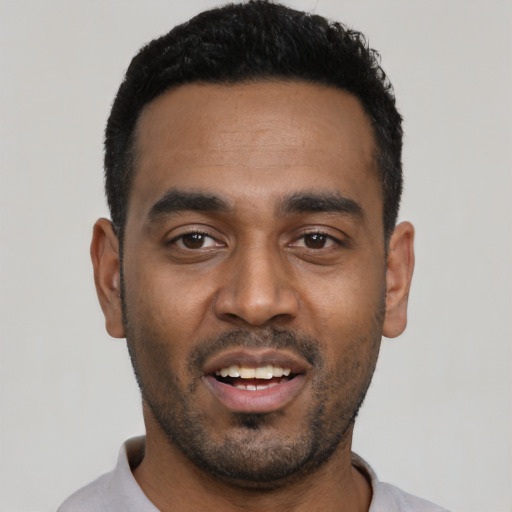 Joyful black young-adult male with short  black hair and brown eyes