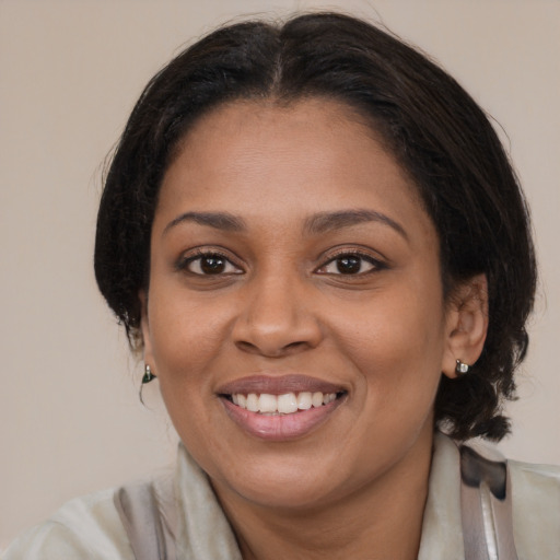 Joyful black young-adult female with medium  brown hair and brown eyes