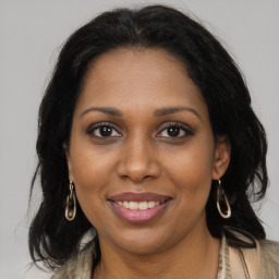 Joyful black young-adult female with long  brown hair and brown eyes