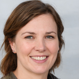 Joyful white young-adult female with medium  brown hair and grey eyes