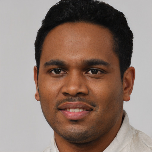 Joyful black young-adult male with short  black hair and brown eyes
