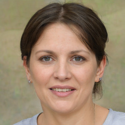 Joyful white adult female with medium  brown hair and grey eyes