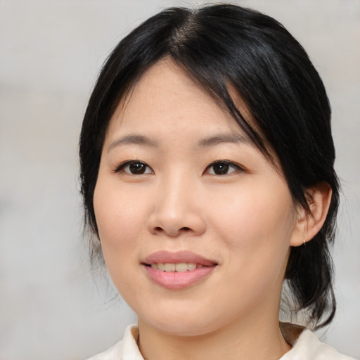 Joyful asian young-adult female with medium  black hair and brown eyes