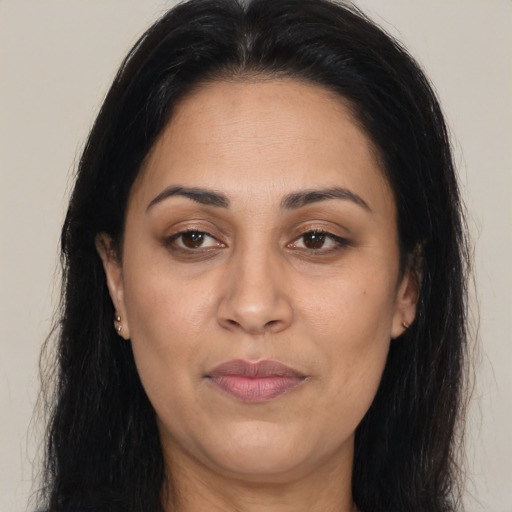 Joyful latino adult female with long  brown hair and brown eyes