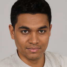 Joyful latino young-adult male with short  black hair and brown eyes