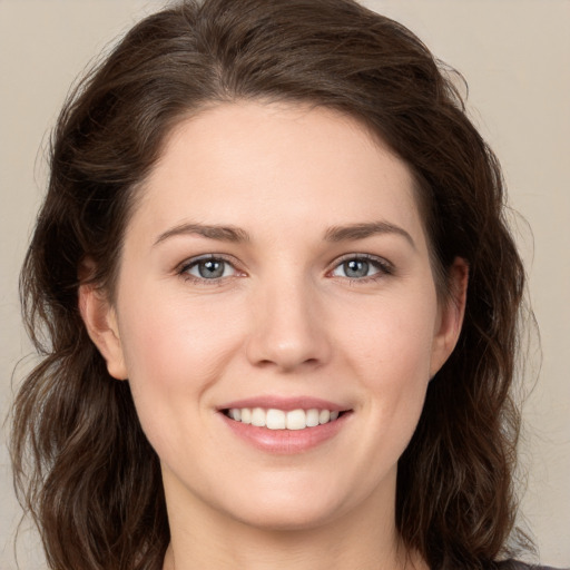 Joyful white young-adult female with medium  brown hair and green eyes