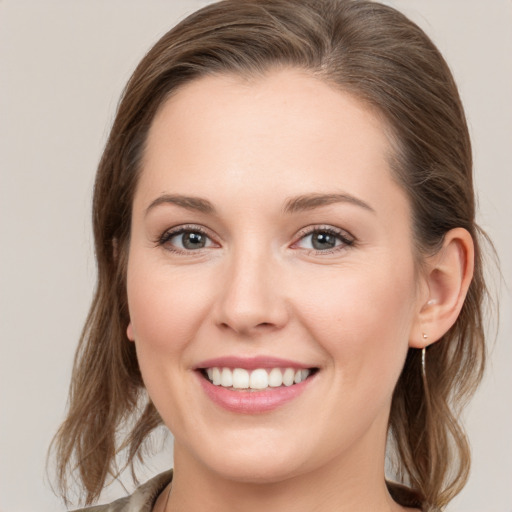 Joyful white young-adult female with medium  brown hair and grey eyes