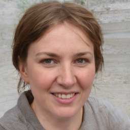 Joyful white adult female with medium  brown hair and grey eyes