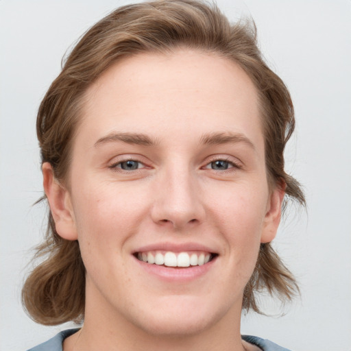 Joyful white young-adult female with medium  brown hair and blue eyes