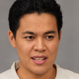 Joyful latino young-adult male with short  brown hair and brown eyes