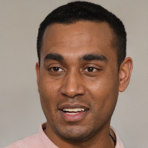 Joyful black young-adult male with short  black hair and brown eyes