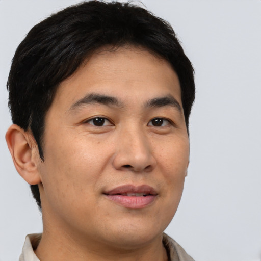 Joyful asian young-adult male with short  brown hair and brown eyes