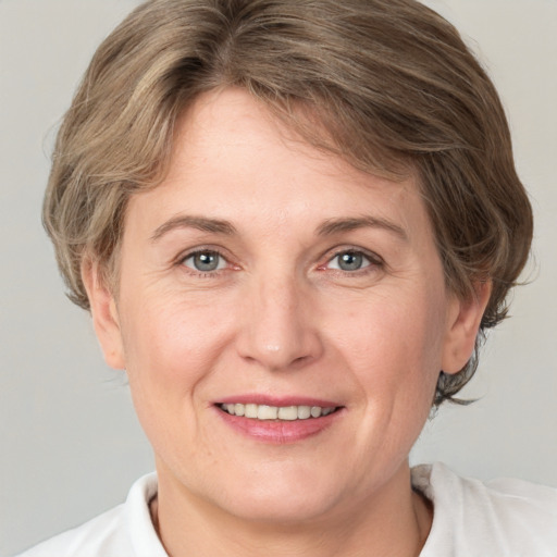 Joyful white adult female with medium  brown hair and grey eyes