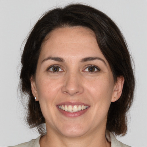 Joyful white adult female with medium  brown hair and brown eyes