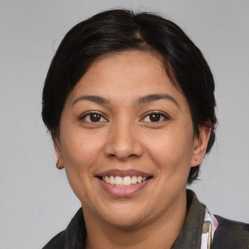 Joyful asian adult female with medium  brown hair and brown eyes