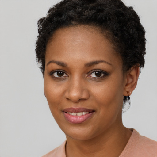 Joyful black young-adult female with short  brown hair and brown eyes