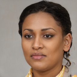 Joyful black young-adult female with long  brown hair and brown eyes