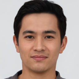 Joyful asian young-adult male with short  black hair and brown eyes