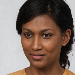 Joyful black young-adult female with medium  brown hair and brown eyes