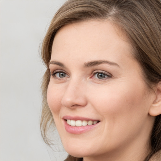 Joyful white young-adult female with long  brown hair and grey eyes