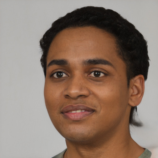 Joyful black young-adult male with short  black hair and brown eyes