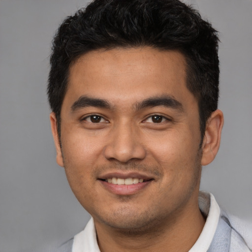 Joyful latino young-adult male with short  brown hair and brown eyes