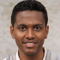 Joyful black young-adult male with short  brown hair and brown eyes