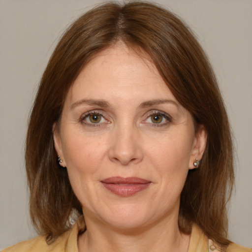 Joyful white adult female with medium  brown hair and green eyes