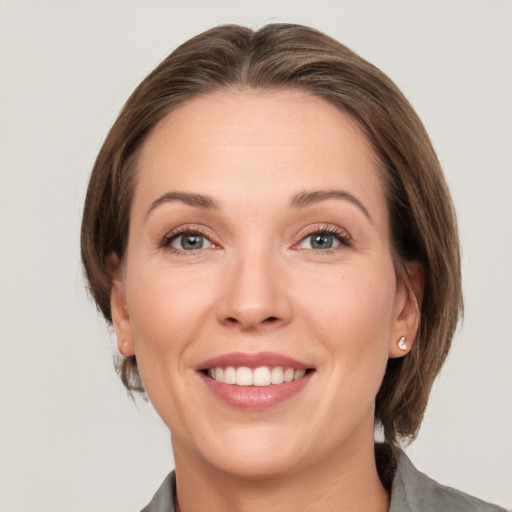 Joyful white young-adult female with medium  brown hair and grey eyes