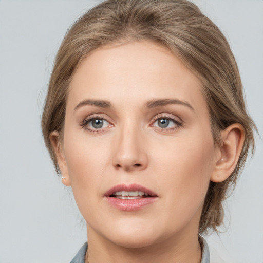 Joyful white young-adult female with medium  brown hair and grey eyes