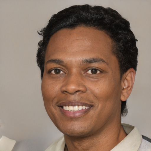 Joyful black adult male with short  black hair and brown eyes