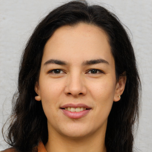 Joyful latino young-adult female with long  brown hair and brown eyes