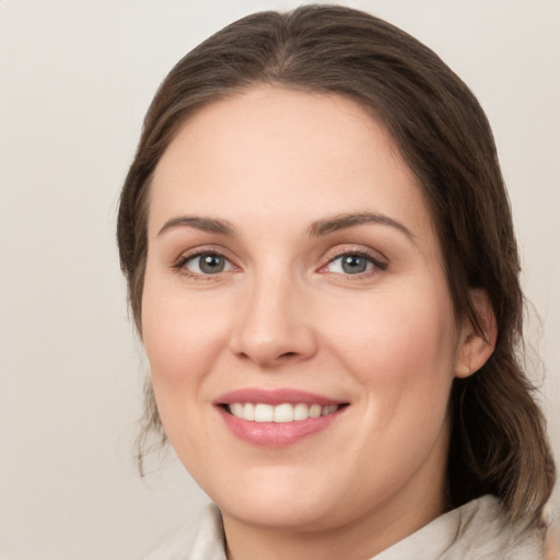 Joyful white young-adult female with medium  brown hair and grey eyes