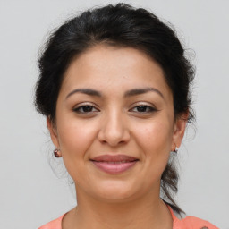 Joyful latino young-adult female with medium  brown hair and brown eyes