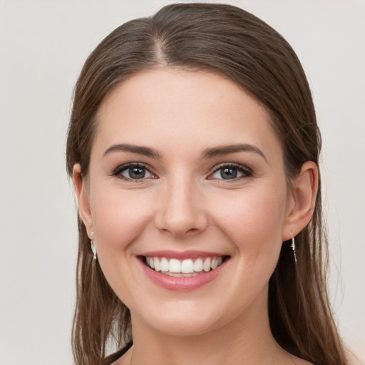 Joyful white young-adult female with long  brown hair and grey eyes