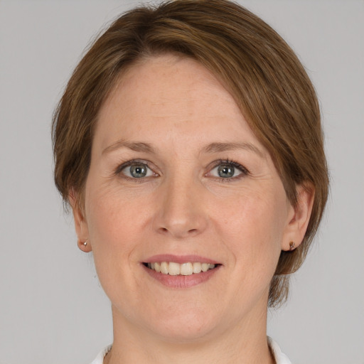 Joyful white adult female with medium  brown hair and grey eyes