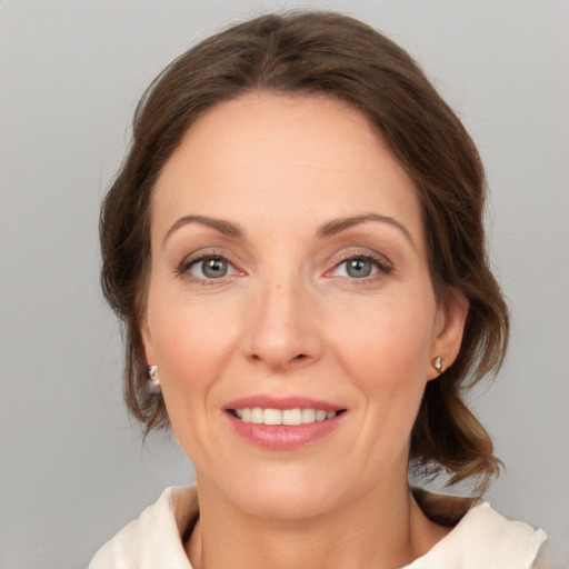 Joyful white adult female with medium  brown hair and grey eyes